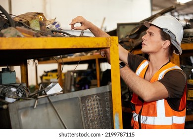 Factory Worker Picking Scrap Metal On Shelf In Old Warehouse