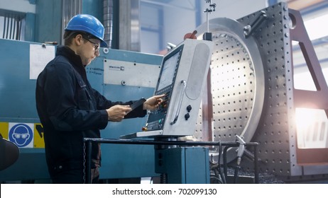 Factory Worker Is Programming A CNC Milling Machine With A Tablet Computer.