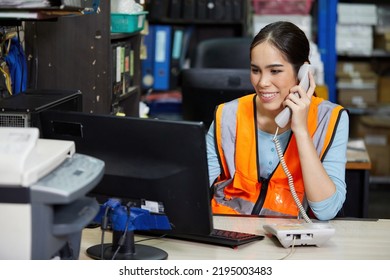 factory worker speaking on the telephone and looking at computer monitor in the office or warehouse storage - Shutterstock ID 2195003483