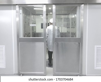 Factory Worker Standing In Air Shower And Dust Removal Room Before Go To Working Area. Clean High-Tech Environment. Clean Room
.blurred Background