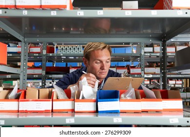 Factory Worker In Store Room Checking Stock