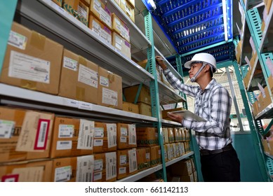 Factory Worker In Store Room Checking Stock