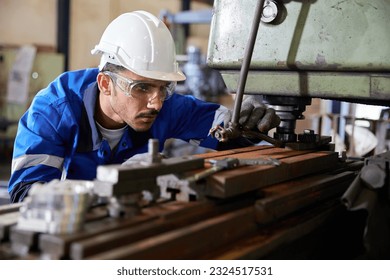 factory worker or technician checking and control lathe machine in factory - Powered by Shutterstock