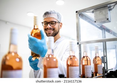 Factory worker or technologist checking quality of bottled wine in alcohol beverage bottling factory. - Powered by Shutterstock