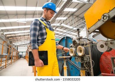 Factory worker using digital tablet while operating machine units in workshop, copy space