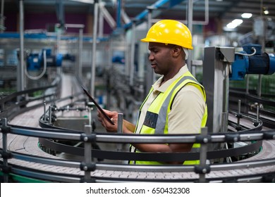 Factory worker using a digital tablet near the production line in factory