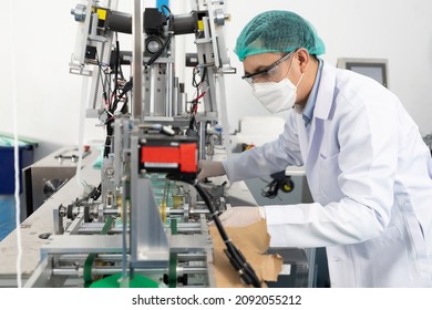 factory worker using machine control panel and producing medical face masks in factory - Shutterstock ID 2092055212