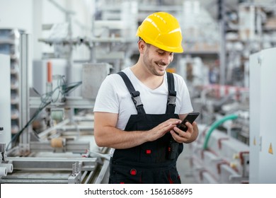 Factory worker using phone. Factory worker talking to smart phone. - Powered by Shutterstock