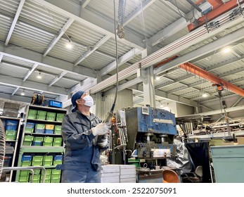 A factory worker using a remote controller to operate a crane - Powered by Shutterstock