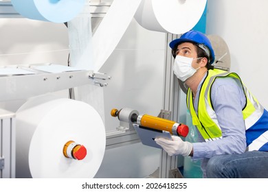 Factory Worker Wearing Medical Face Mask And Checking Production Line For Quality Control From Non Woven Material On Automatic Machine