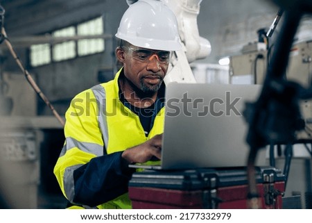 Factory worker working with laptop computer to do adept procedure checklist . Factory production line operator occupation quality control concept .