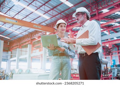 Factory workers or engineer worker working for check and analyze newly arrived goods using laptop and digital tablet, teamwork and synergy concept, vintage tone.