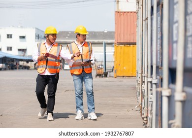 factory workers or engineers talking and exploring container in factory workshop