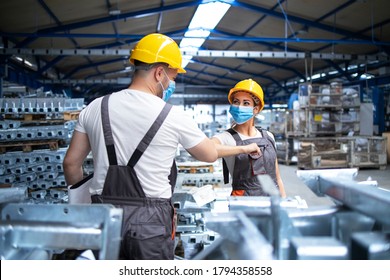 Factory Workers Greeting Each Others With Elbows During Corona Virus Pandemic. Industrial Employees Wearing Protection Masks Due To COVID-19 Infection.