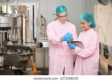 factory workers holding and checking basil seed drinks in the beverage factory - Powered by Shutterstock