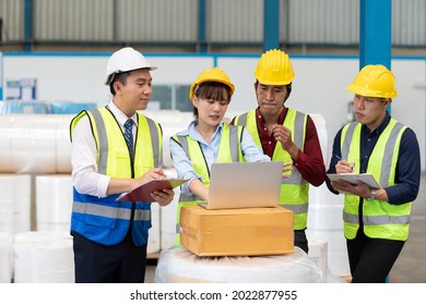 Factory Workers Meeting And Using Laptop Computer For Work In Warehouse Storage