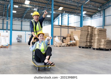 factory workers moving cart and funny pose in warehouse storage