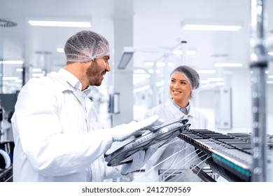 Factory workers operating advanced semiconductor production machine in automotive industry. - Powered by Shutterstock