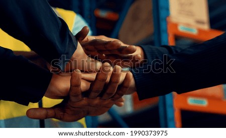 Factory workers stacking hands together in warehouse or storehouse . Logistics , supply chain and warehouse business concept .