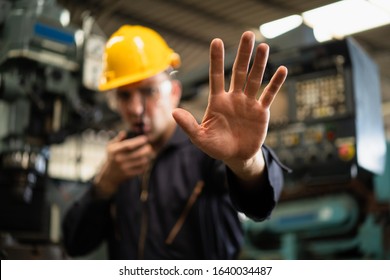 Factory zone restricts access industrial area, Industrial worker in factory site gesture keep out while communicating with a walkie talkie, Concept Disallow warning, working profession, call police. - Shutterstock ID 1640034487