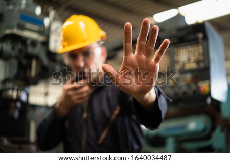 Factory zone restricts access industrial area, Industrial worker in factory site gesture keep out while communicating with a walkie talkie, Concept Disallow warning, working profession, call police.