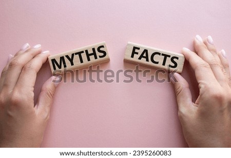 Facts or Myths symbol. Concept word Facts or Myths on wooden blocks. Businessman hand. Beautiful pink background. Business and Facts or Myths concept. Copy space
