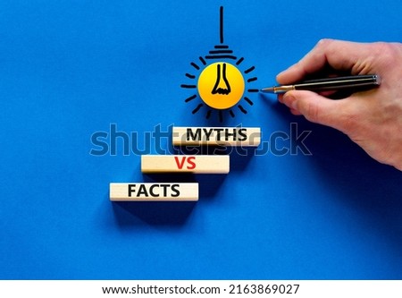 Facts vs myths symbol. Concept words Facts vs myths on wooden blocks on a beautiful blue table blue background. Businessman hand. Business, finacial and facts vs myths concept. Copy space.