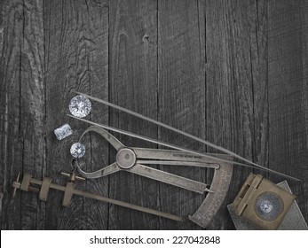 faded colors vintage jewelers tools and diamonds over wooden bench, space for text