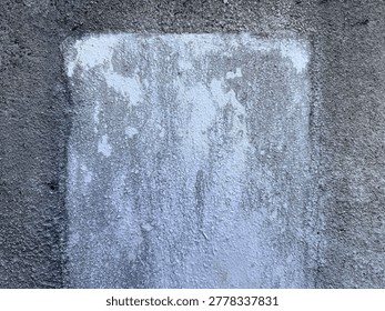 Faded rectangular white paint on rough grey concrete creates an abstract background.