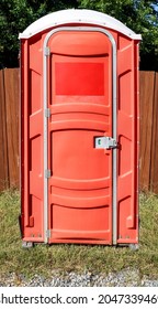 Faded Reddish Orange Porta Potty.