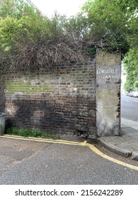 Faded Sign On A Brick Wall Corner