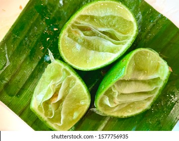 Faded squeezed lime, ingredients in papaya salad, Remaining peels of lemon after squeezing, top view of fresh lemons on wooden table, Food ingredient concept, Residue of food background