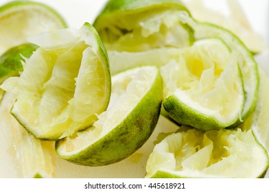 Faded squeezed lime on white background, Remaining peels of lemon after squeezing, top view of fresh lemons on wooden table, Food ingredient concept, Residue of food background