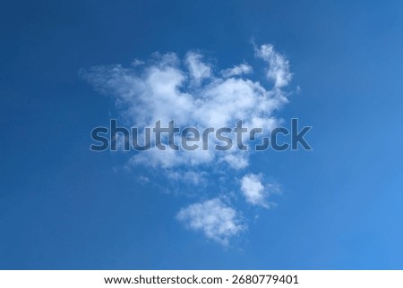 A fading, dissolving feather cloud. A cirrus clouds against a blue background. Relaxed cotton wool distributes the smoke into a loose structure. Light fluffy texture on a warm summer day.