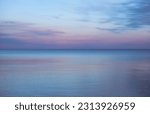 A fading pink and purple sunset over the lake on a peaceful evening in Toronto, Ontario, Canada. The blue colours of dusk make the scene look almost unreal.