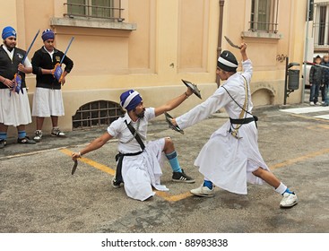 FAENZA, ITALY - NOVEMBER 6: indians Sikh in traditional costume performing a knife duel with a old fighting weapon at "Fiera di San Rocco" that hosts historical recalling on November 6, 2011 in Faenza