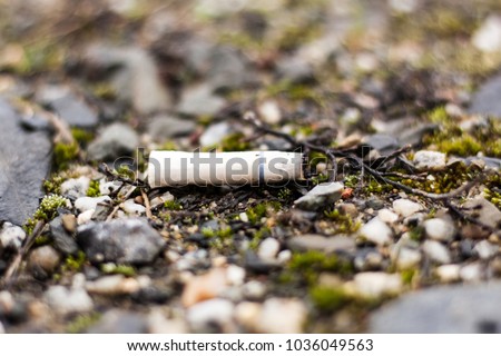 fag end cigarette butt stub outdoor stone ground closeup