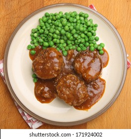 Faggots (traditional offal meatballs) with peas and gravy.