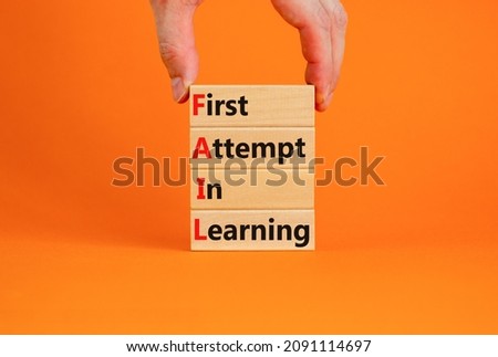 FAIL first attempt in learning symbol. Wooden blocks with words FAIL first attempt in learning. Beautiful orange table, orange background, copy space. Business, FAIL first attempt in learning concept.