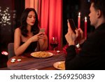 Failed romantic date. Man and woman absorbed with mobile phones, ignoring each other during Valentine