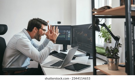 Failing Frustrated young businessman or trader in formalwear is shouting and feeling angry while looking at trading charts and financial data in the office. - Powered by Shutterstock