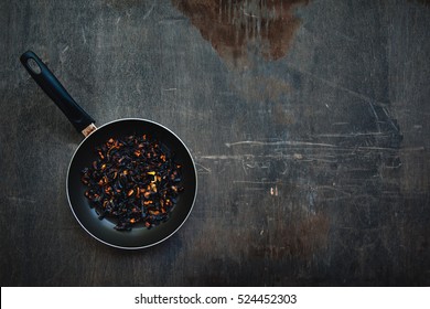 The Failure On Kitchen: Burnt Charred Vegetables. Frying Pan With Refried Black Onion And Overcooked Orange Carrots. Cooking Fail Concept Background With Copy Space.