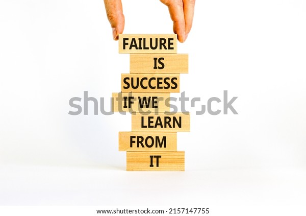 Failure or success symbol. Wooden blocks with words Failure is success if we learn from it. Beautiful white background, copy space. Businessman hand. Business, learn from failure or success concept.