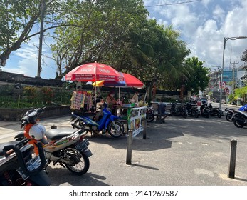 A Fair Day In A Big City In Indonesia. Motorbikes Parked On A Busy Street. Motorcycles. Tent. Trees. Food Sale. Red. Blue. Gray. Bali, Indonesia. 02.11.2022