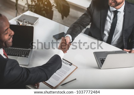 Similar – Image, Stock Photo Two young men shake hands. Close up of the hands in front of a green background.