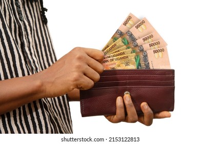 fair Female Hand Holding brown Purse With Ugandan shilling notes, hand removing money out of purse isolated on white. removing money from wallet