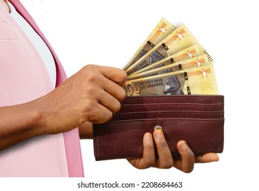 Fair Female Hand Holding Brown Purse With Zimbabwean Dollar Notes, Hand Removing Money Out Of Purse Isolated On White Background