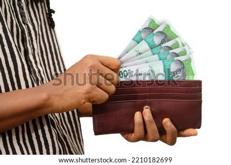 fair Female Hand Holding brown Purse With Colombian peso notes, hand removing money out of purse isolated on white background