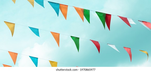 Fair flag bunting colorful background hanging on blue sky for fun fiesta party event, summer holiday farm feast celebration, carnival festival event, park or street festa design decoration - Powered by Shutterstock