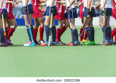 Fair Play concept for sportsmanship, showing two oppsing teams of women field hockey players shaking hands after the line-up of an important match.